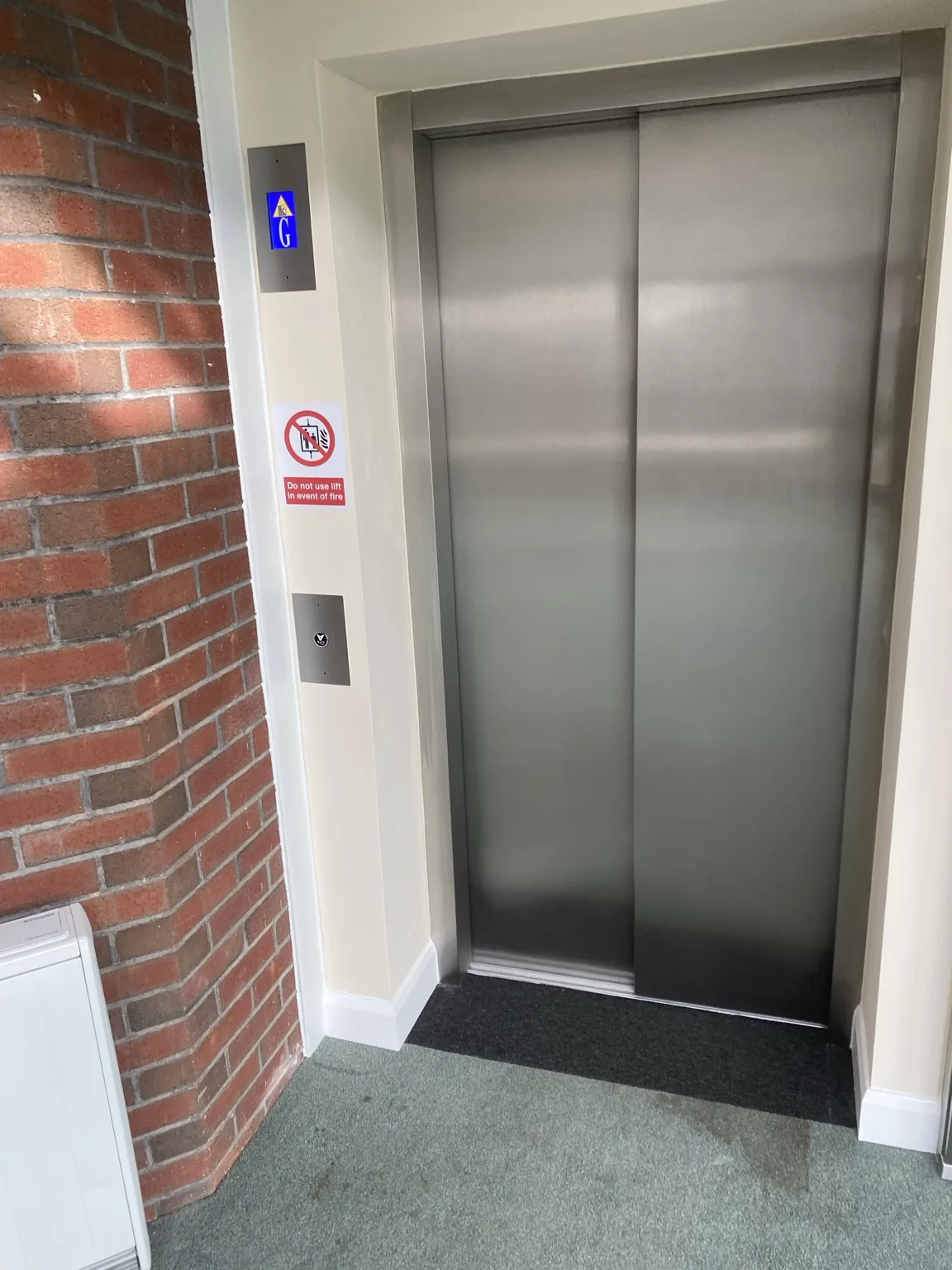 Completed lift entrance beside brick wall