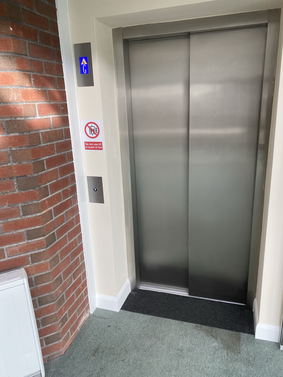 Completed lift entrance beside brick wall
