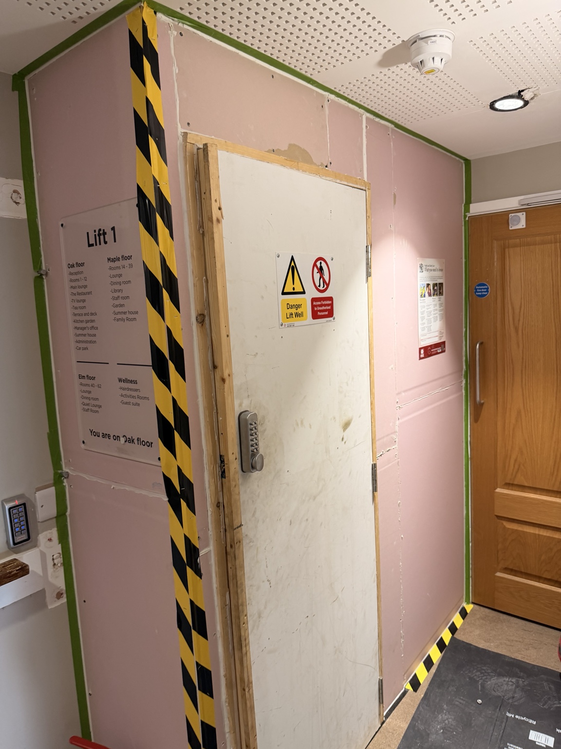 Fire-rated boarded hoarding with controlled access